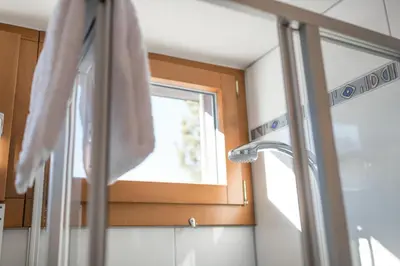 a bathroom mirror with a sink and a window at Chalet Pfiff in Wildhaus