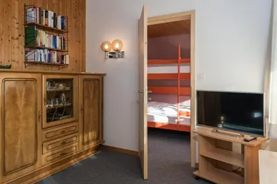 a bedroom with a tv and a bedroom with a bed at Chalet Pfiff in Wildhaus