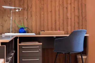 a desk with a blue chair and a desk with a lamp at Schwalbennest in Wildhaus