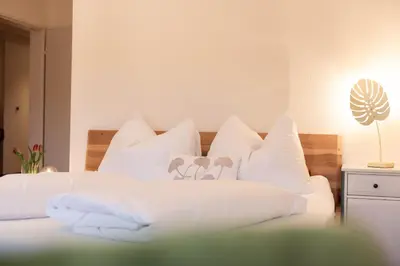 a bedroom with a white bed with white pillows at Schwalbennest in Wildhaus