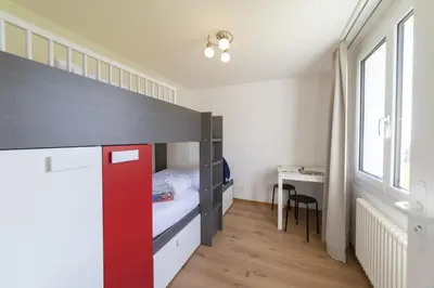 a bedroom with a bunk bed with a red door at Lisighaus in Wildhaus