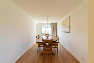 a dining room with a wooden table and chairs at Lisighaus in Wildhaus