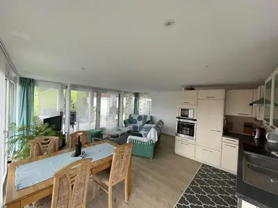 a kitchen and living room with a table and chairs at Hälmli in Heiden