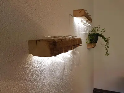 a light on a wall with a plant on it at Ferien im Gugger in Nesslau