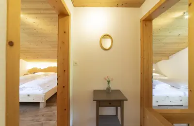 a room with two beds and a table with a mirror at Schönau in Wildhaus