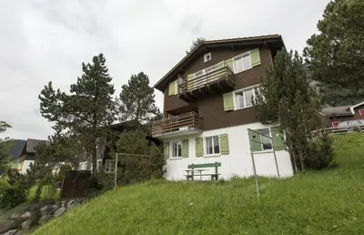 a house on top of a grassy hill at Chalet Ritornell in Wildhaus