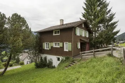 a house on top of a grassy hill at Chalet Ritornell in Wildhaus