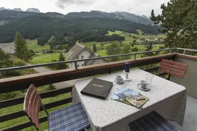 a table and chairs on a balcony with a view at Chalet Ritornell in Wildhaus