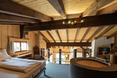 a large room with a bed and a fireplace at Tanzhaus in Wildhaus