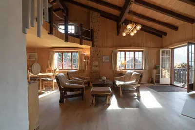 a living room with chairs and a table and windows at Tanzhaus in Wildhaus