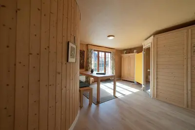 a room with wooden walls and a table and a window at Tanzhaus in Wildhaus