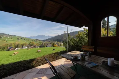 a porch with a table and a view of a field at Tanzhaus in Wildhaus