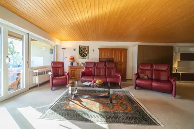 a living room with two red chairs and a table at Haldenblick in Unterwasser