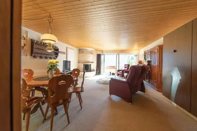 a dining room and living room with a table and chairs at Haldenblick in Unterwasser