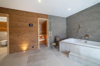a bathroom with a bath tub and a toilet at Chalet Hinterrugg in Wildhaus