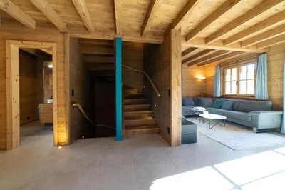 a living room with a staircase in a wooden house at Chalet Gamserrugg in Wildhaus