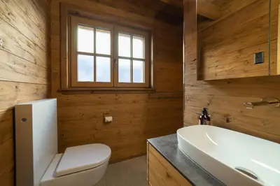 a bathroom with a toilet and a sink and a tub at Chalet Gamserrugg in Wildhaus