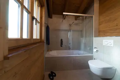 a bathroom with a bath tub and a toilet at Chalet Gamserrugg in Wildhaus