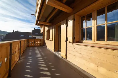 a balcony of a wooden house with windows at Chalet Chäserrugg in Wildhaus
