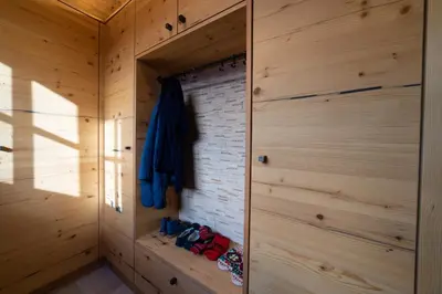 a room with wooden walls and a closet with shoes at Chalet Chäserrugg in Wildhaus