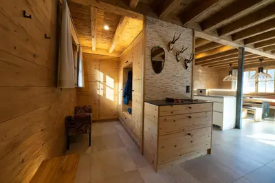 a kitchen with wooden walls and a dresser in a room at Chalet Chäserrugg in Wildhaus