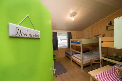 a room with a green wall and a bunk bed at Hof-Tschannen in Lengwil