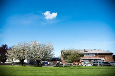 a building in a field with trees in front of it at Hof-Tschannen in Lengwil