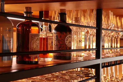 a shelf filled with bottles and glasses of alcohol at Hotel Restaurant Rössli in Alt Sankt Johann