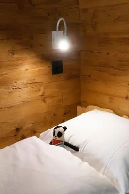 a panda doll sitting on a bed in a bedroom at Chalet Zuestoll in Wildhaus
