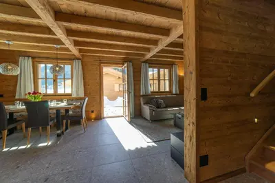 a dining room with a table and a couch at Chalet Zuestoll in Wildhaus