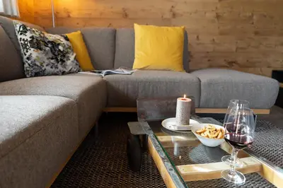a living room with a couch and a table with a candle at Chalet Schafberg in Wildhaus