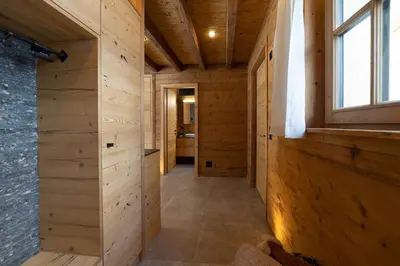 a hallway in a house with wooden walls and a window at Chalet Schafberg in Wildhaus