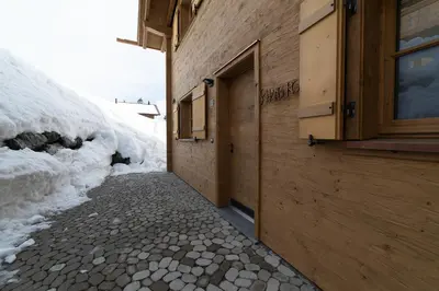 a stone walkway next to a building with a door at Chalet Schafberg in Wildhaus