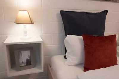a lamp on a night stand next to a bed at BnB Alpenblick in Lütisburg