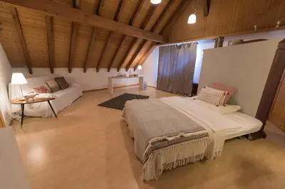 a large bedroom with a bed and a couch at BnB Alpenblick in Lütisburg