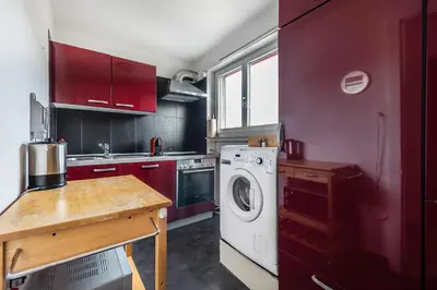 a kitchen with a washing machine and a wooden table at SOHO F !Gratis Parken, Free Parking! in Kreuzlingen