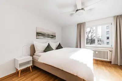 a white bedroom with a large bed and a window at SOHO F !Gratis Parken, Free Parking! in Kreuzlingen