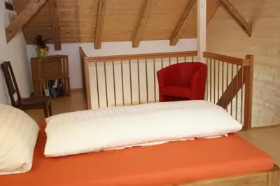 a bedroom with a bed and a red chair at BnB Haag in Haag