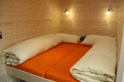 two beds in a room with an orange mattress at BnB Haag in Haag