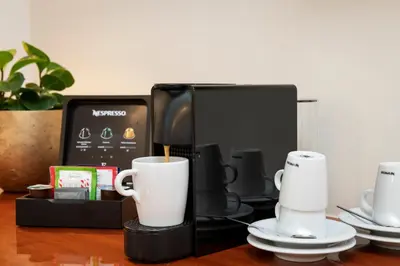 a coffee maker with two cups on a table at Einstein St. Gallen in St. Gallen