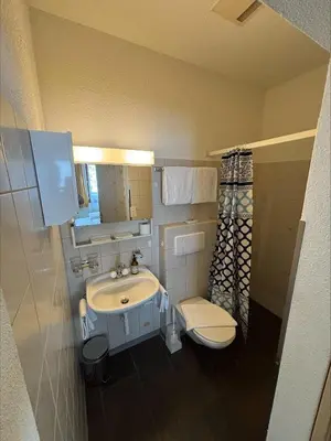 a small bathroom with a sink and a toilet at Hirschen Guesthouse - Village Hotel in Wildhaus