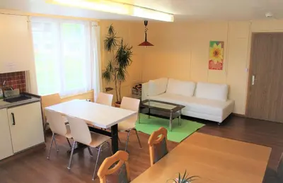 a living room with a table and a white couch at Galluszentrum in Wildhaus