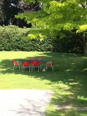 a table and chairs in a field with trees at Schloss Brunnegg in Kreuzlingen