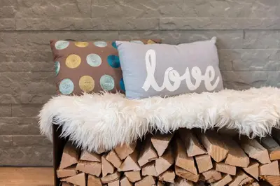 a bench with pillows on it next to a brick wall at Neuhof Gäste-& Schokohaus in Appenzell