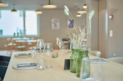 a table with glasses and jars with flowers in them at Hotel Balga Natur- und Bikehotel in Balgach