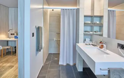 a bathroom with a white sink and a shower at Hotel Balga Natur- und Bikehotel in Balgach