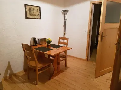 a dining room table with two chairs and a lamp at Bio Hof Moosburg am See mit Sauna in Güttingen