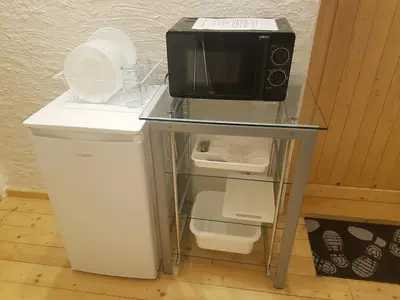 a microwave sitting on top of a table with a refrigerator at Bio Hof Moosburg am See mit Sauna in Güttingen