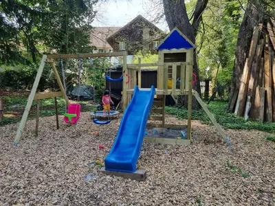 a playground with a slide and a swing at Bio Hof Moosburg am See mit Sauna in Güttingen