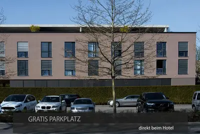 a parking lot with cars parked in front of a building at Hotel Kreuzlingen am Hafen in Kreuzlingen